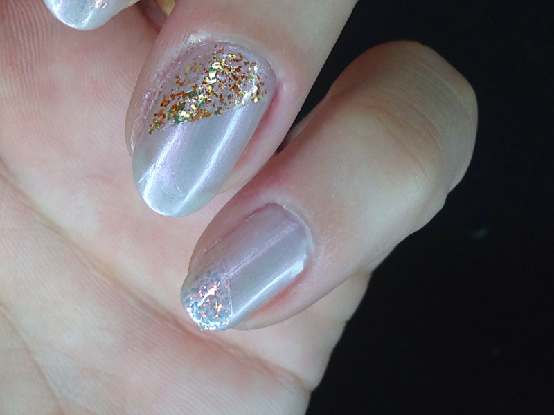 Step 3: Paint over the tape using the sparkly polish. I chose to alternate nails, so only my pointer and ring fingers have the gold sparkles; the rest have the iridescent. Remove the tape while this polish is still a little damp. Allow it to dry.